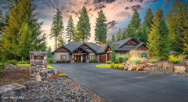 craftsman-style home featuring driveway, a chimney, and a garage