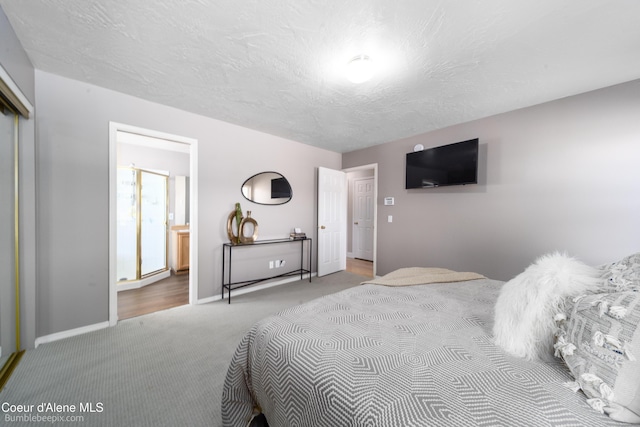 carpeted bedroom with baseboards, a textured ceiling, and ensuite bathroom