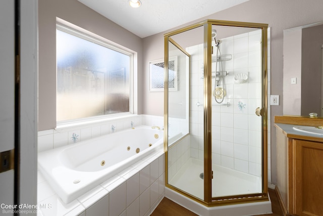 full bathroom with vanity, a jetted tub, and a stall shower