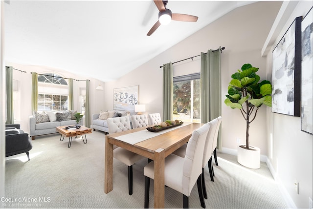 dining room featuring light colored carpet, baseboards, lofted ceiling, and a ceiling fan