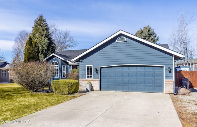 ranch-style home with brick siding, fence, a front yard, a garage, and driveway