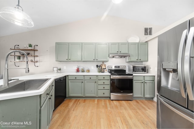 kitchen with under cabinet range hood, a sink, stainless steel appliances, and green cabinetry