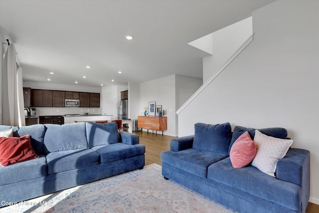 living area featuring recessed lighting, stairs, and light wood-type flooring