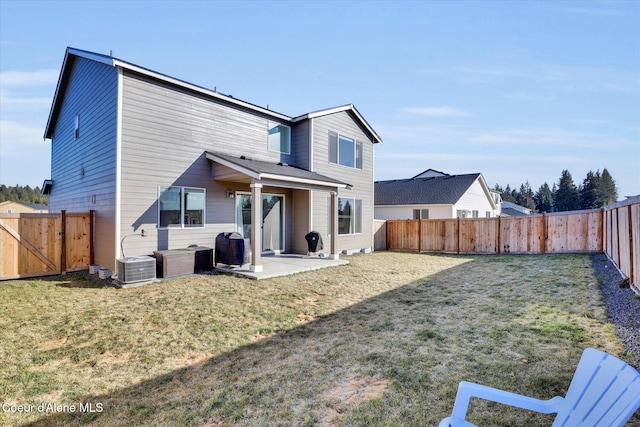 rear view of property featuring a lawn, a patio, central AC, and a fenced backyard