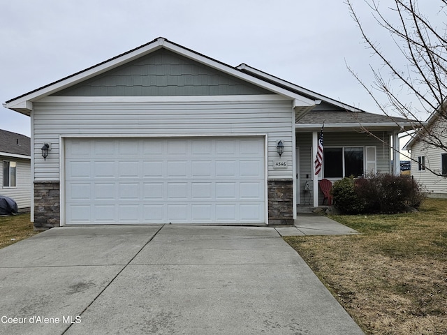 view of front of property with stone siding, a front yard, concrete driveway, and an attached garage