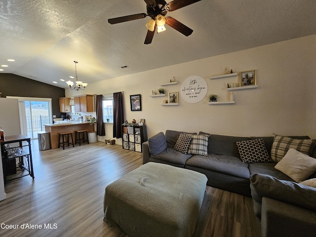 4346 N Brookie Dr, Post Falls, ID 83854 - living room featuring ceiling fan with notable chandelier, lofted ceiling, a textured ceiling, and wood finished floors