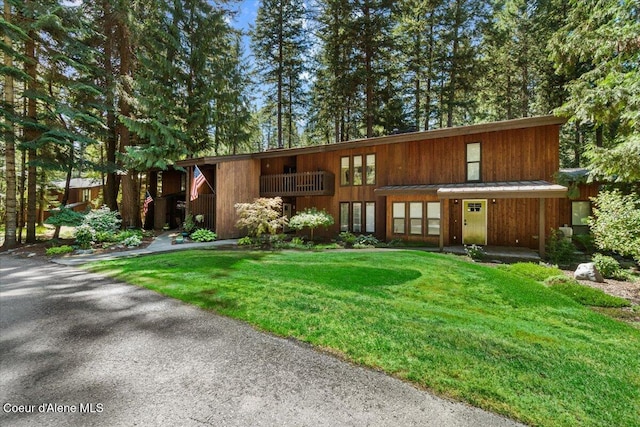 view of front of house featuring a standing seam roof, metal roof, and a front lawn