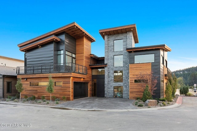 contemporary home featuring a balcony and an attached garage