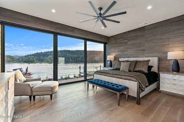 bedroom featuring visible vents, a water view, recessed lighting, wood finished floors, and a ceiling fan