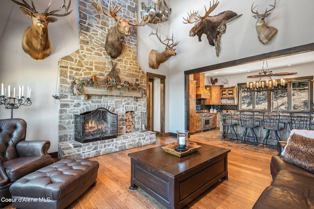 living area featuring a high ceiling, a fireplace, and wood-type flooring