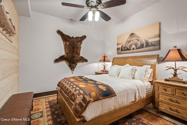 bedroom with visible vents, wood finished floors, and a ceiling fan