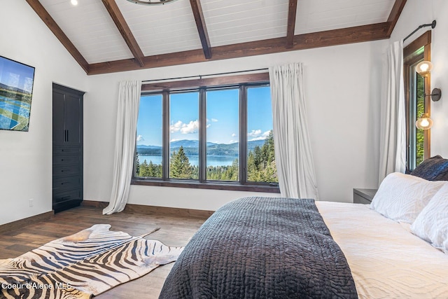 bedroom with vaulted ceiling with beams, wood finished floors, a mountain view, and baseboards