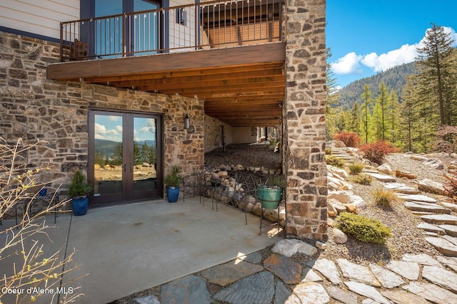 view of patio / terrace with french doors and a wooded view