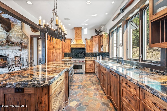 kitchen with stone finish flooring, a center island, dark stone counters, decorative backsplash, and custom exhaust hood