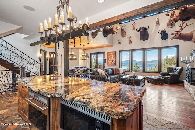 kitchen with stainless steel microwave, a notable chandelier, open floor plan, and a wealth of natural light