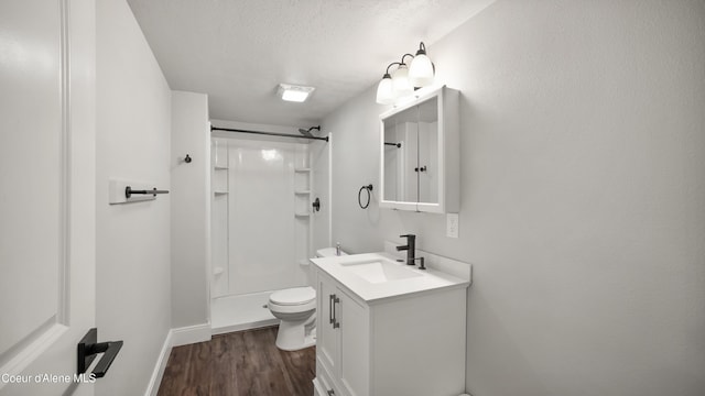 full bathroom with toilet, a textured ceiling, wood finished floors, a shower, and vanity