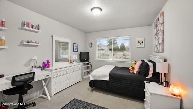 bedroom with light colored carpet and a textured ceiling