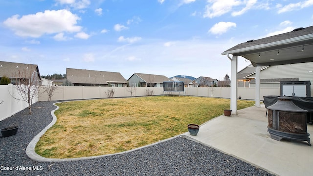 view of yard with a patio, a trampoline, and a fenced backyard