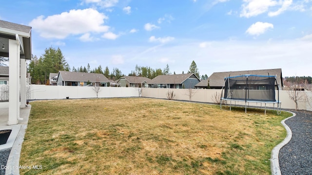 view of yard featuring a trampoline and a fenced backyard