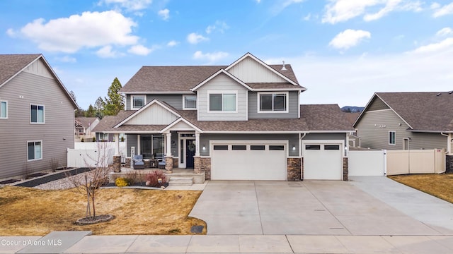 craftsman house featuring a gate, fence, a shingled roof, concrete driveway, and a garage