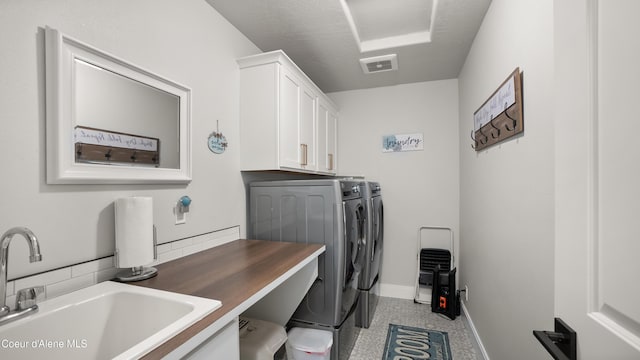 laundry room featuring visible vents, baseboards, cabinet space, a sink, and independent washer and dryer