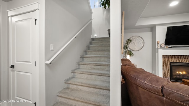 staircase featuring a tiled fireplace