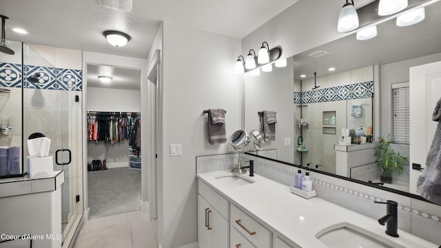 full bathroom with double vanity, a stall shower, and a sink