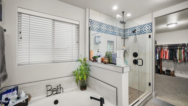 full bathroom with recessed lighting, a walk in closet, a bath, and a shower stall