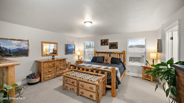 bedroom featuring a textured ceiling, visible vents, baseboards, and light carpet