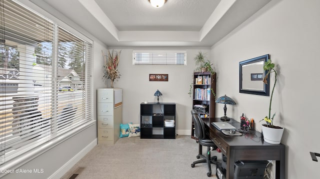 office area featuring visible vents, a tray ceiling, a textured ceiling, carpet floors, and baseboards