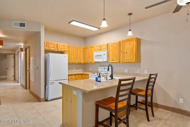 kitchen featuring visible vents, a sink, white appliances, a peninsula, and hanging light fixtures