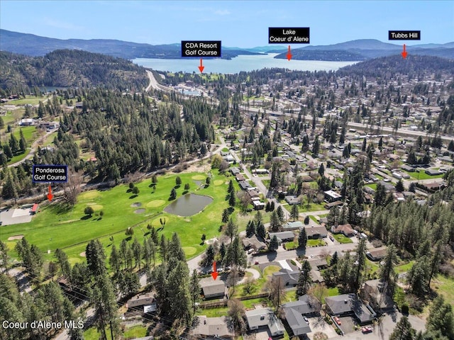 drone / aerial view with golf course view and a water and mountain view