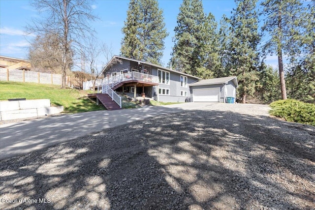 view of front of property with fence, driveway, stairs, an outdoor structure, and a deck