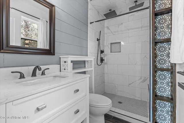 bathroom featuring vanity, a shower stall, and toilet