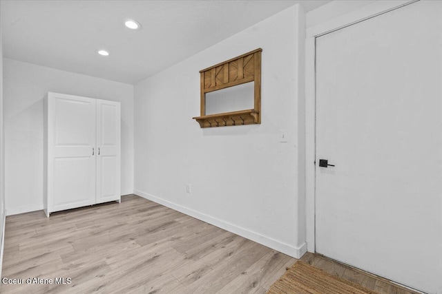 spare room featuring recessed lighting, light wood-type flooring, and baseboards