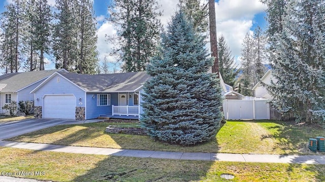 ranch-style house featuring fence, a front yard, covered porch, a garage, and driveway