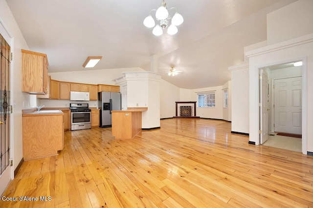 kitchen with light wood-type flooring, ceiling fan with notable chandelier, open floor plan, appliances with stainless steel finishes, and lofted ceiling