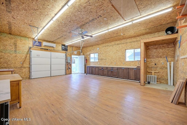 garage with a ceiling fan and a wall unit AC