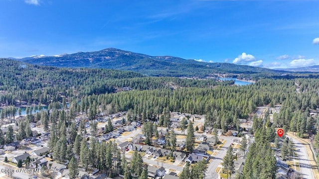 aerial view featuring a view of trees and a water and mountain view