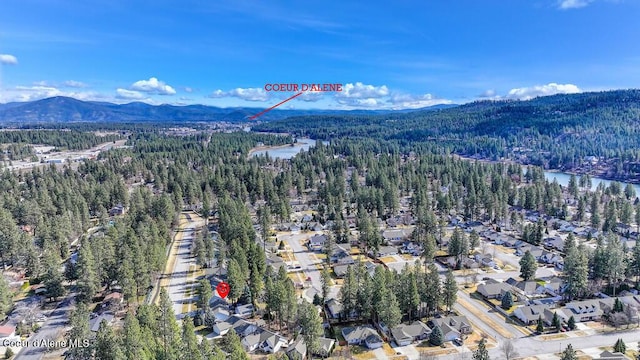 aerial view featuring a forest view and a water and mountain view