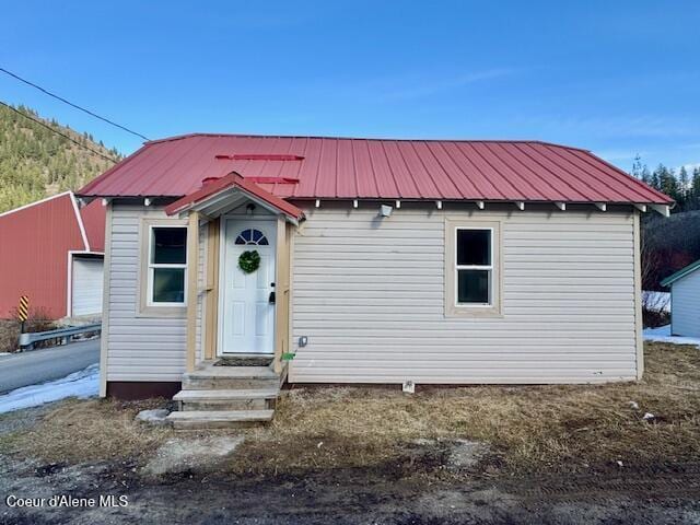 view of front of house featuring a standing seam roof, an outbuilding, and metal roof