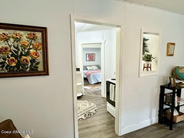 corridor featuring wood finished floors and baseboards