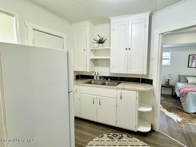 kitchen with open shelves, freestanding refrigerator, dark wood-style floors, white cabinets, and a sink