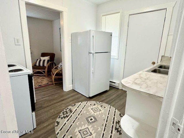 kitchen featuring white appliances, dark wood-style floors, a sink, light countertops, and baseboard heating