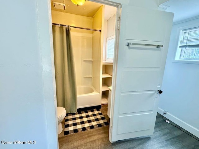 full bathroom featuring toilet, wood finished floors, baseboards, and shower / tub combo with curtain