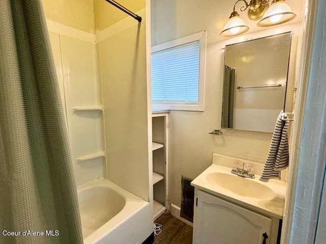 full bath featuring visible vents, vanity, shower / bath combo with shower curtain, and wood finished floors