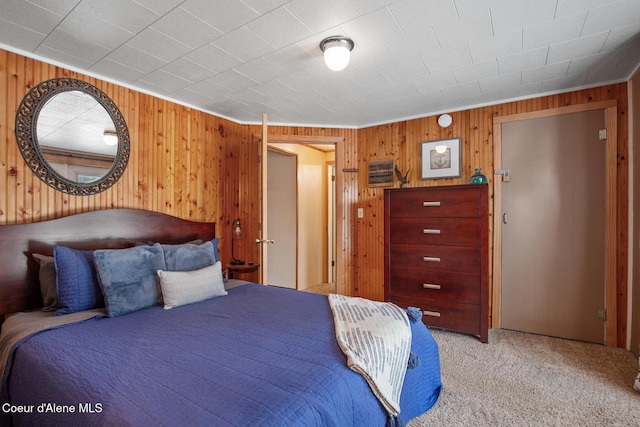 bedroom featuring wooden walls and light colored carpet