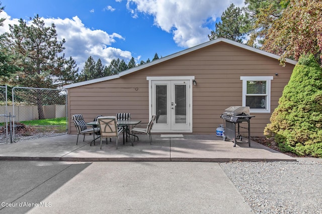 rear view of property with french doors, a patio, and fence