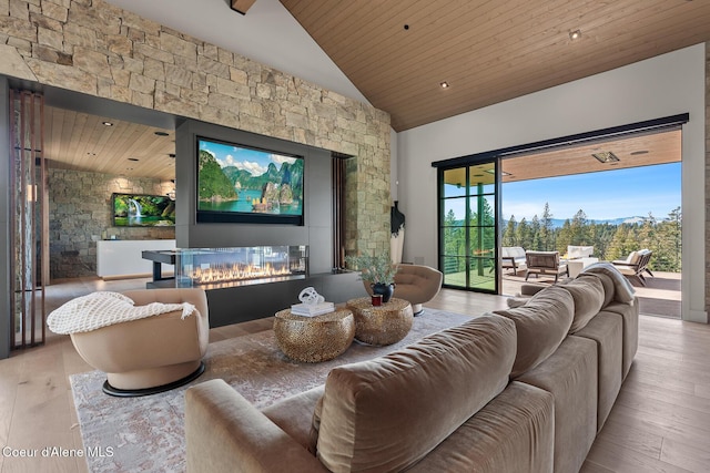 home theater room featuring a multi sided fireplace, wood finished floors, high vaulted ceiling, and wooden ceiling