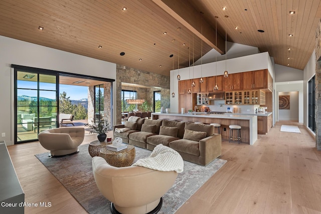 living area featuring wooden ceiling, a healthy amount of sunlight, light wood-style floors, and high vaulted ceiling